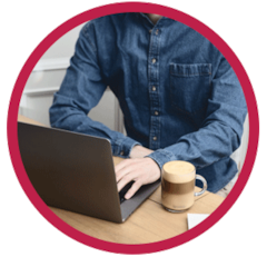 Man working on a laptop with a Nespresso Coffee